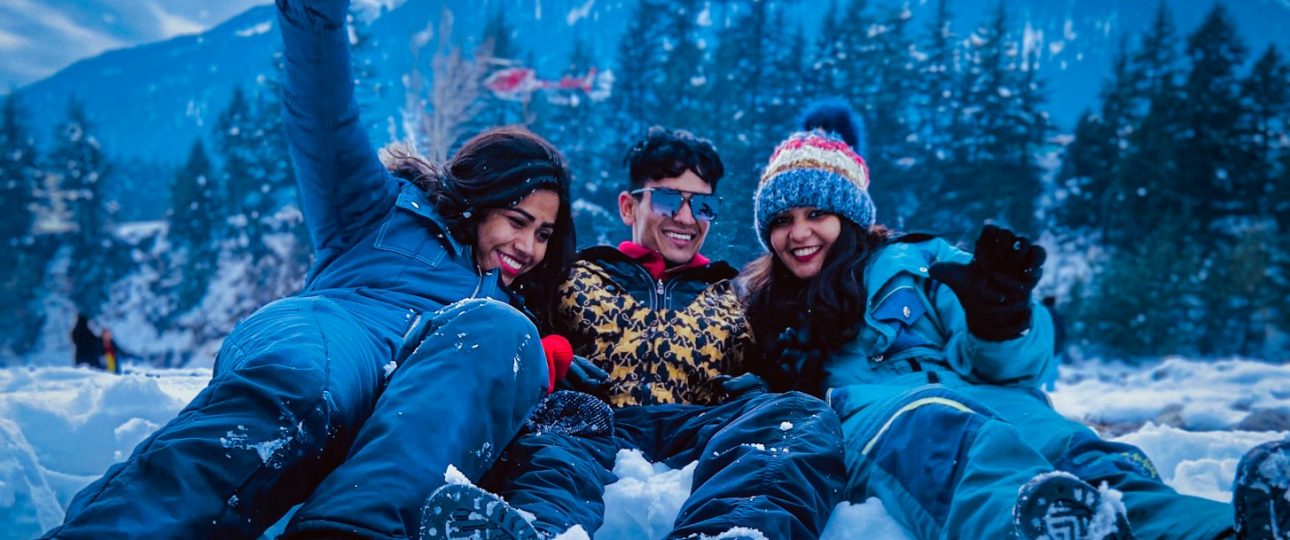 3 women lying on snow covered ground during daytime