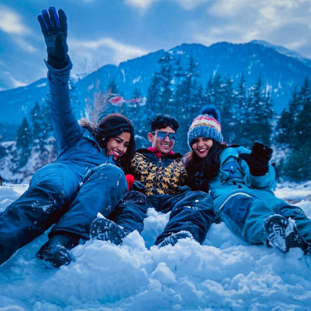 3 women lying on snow covered ground during daytime